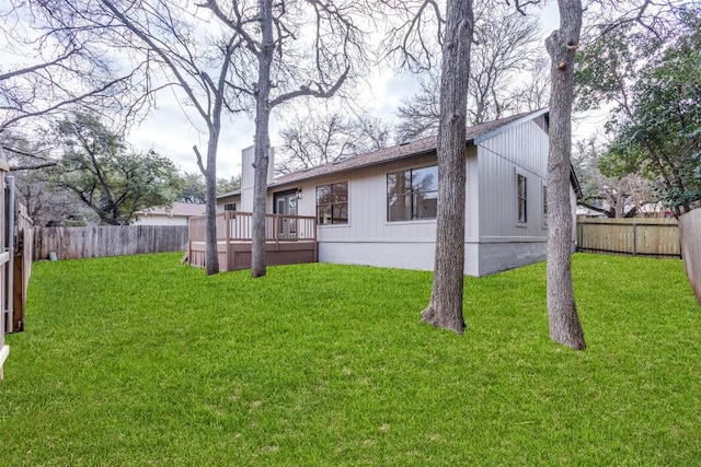 back of property with a yard and a deck