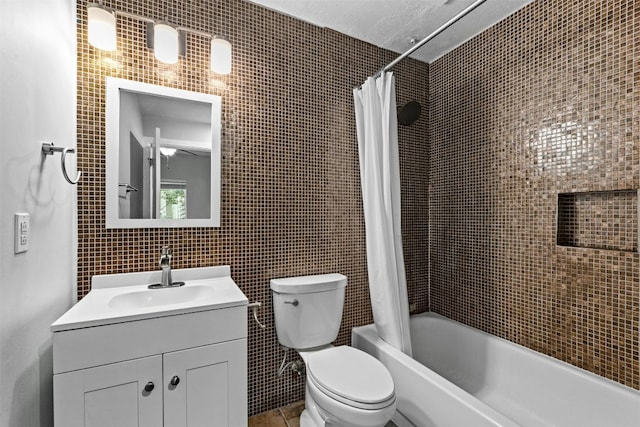 full bathroom with shower / tub combo with curtain, vanity, toilet, and tile walls