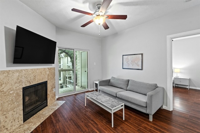 living room with dark hardwood / wood-style flooring, a fireplace, and ceiling fan