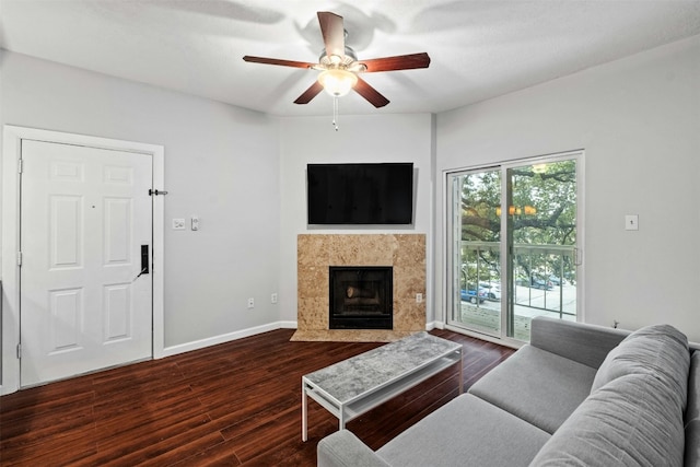 living room with a tile fireplace, dark hardwood / wood-style floors, and ceiling fan