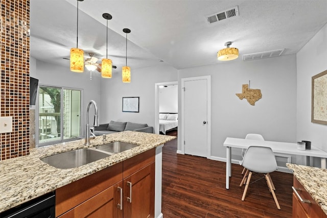 kitchen featuring decorative light fixtures, black dishwasher, sink, dark hardwood / wood-style flooring, and decorative backsplash