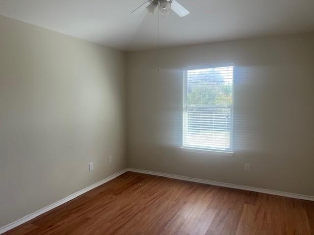 empty room featuring ceiling fan and hardwood / wood-style floors