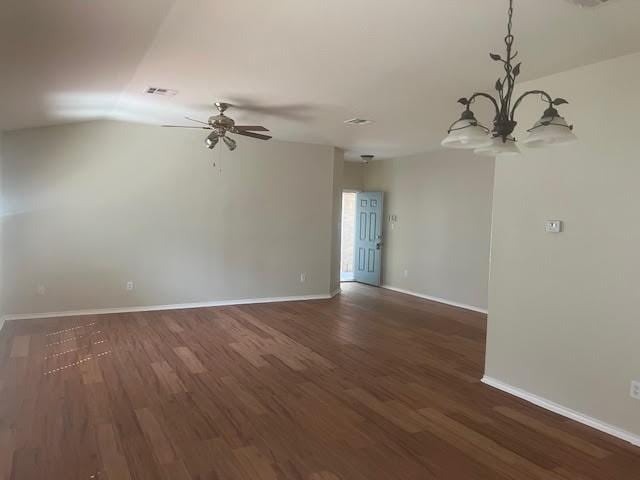 spare room with dark hardwood / wood-style flooring and ceiling fan with notable chandelier