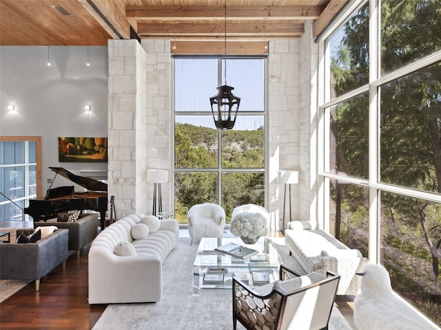 sunroom / solarium featuring decorative columns, wooden ceiling, and beam ceiling