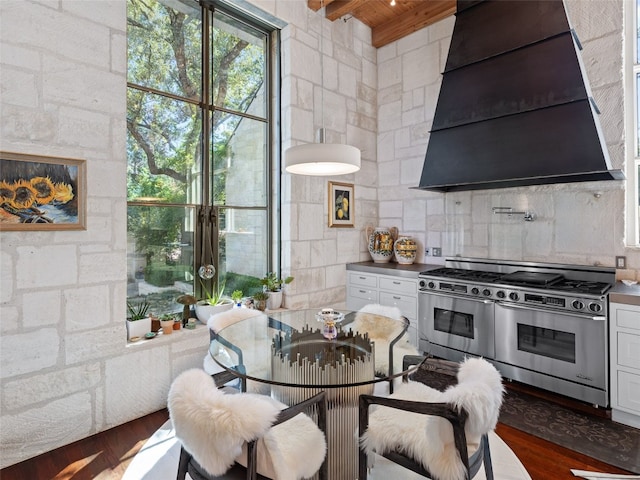 1200 Barton Creek Blvd Unit 35, Austin, TX 78735 - kitchen featuring range with two ovens, exhaust hood, white cabinetry, dark wood finished floors, and wooden ceiling