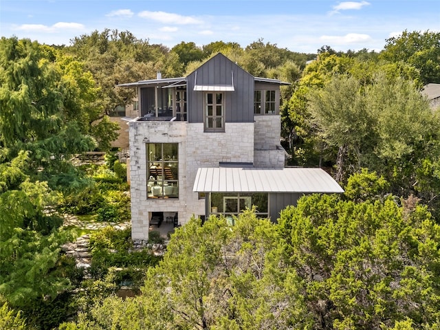 1200 Barton Creek Blvd Unit 35, Austin, TX 78735 - rear view of property featuring board and batten siding, stone siding, a standing seam roof, and a metal roof
