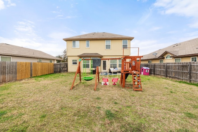 rear view of property featuring a yard and a playground