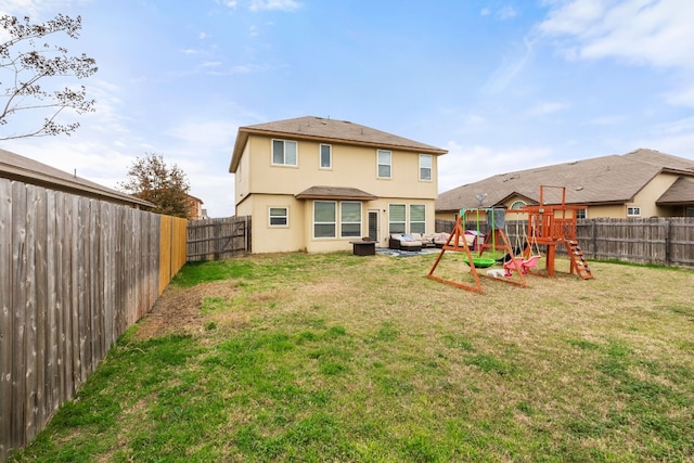 back of house with a yard and a playground