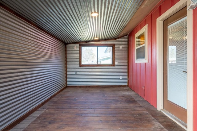 exterior space with dark wood-type flooring and vaulted ceiling