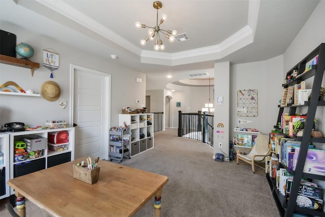 recreation room with crown molding, a raised ceiling, carpet floors, and a notable chandelier