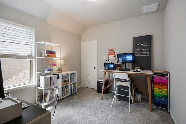 carpeted home office with vaulted ceiling