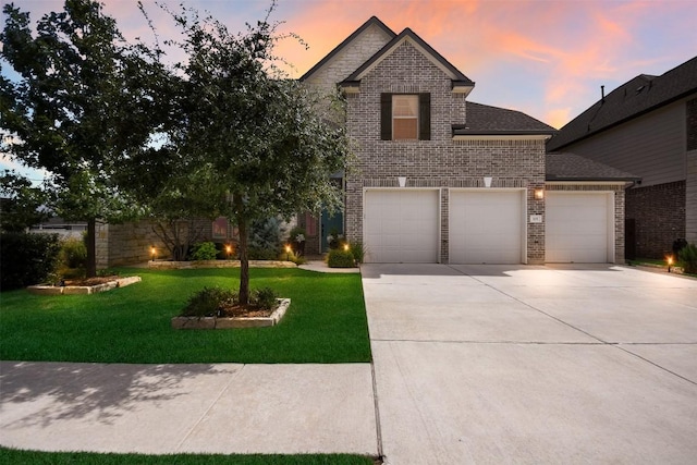 view of front of property with a garage and a lawn