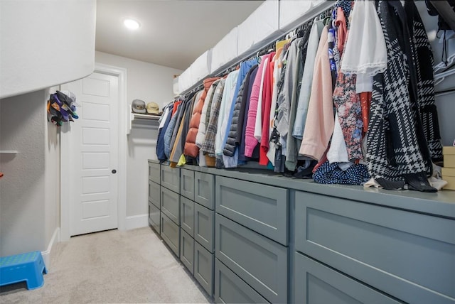 spacious closet featuring light colored carpet