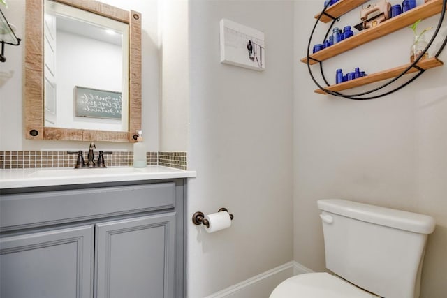 bathroom with tasteful backsplash, vanity, and toilet