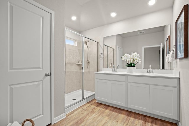 bathroom with vanity, hardwood / wood-style floors, and an enclosed shower