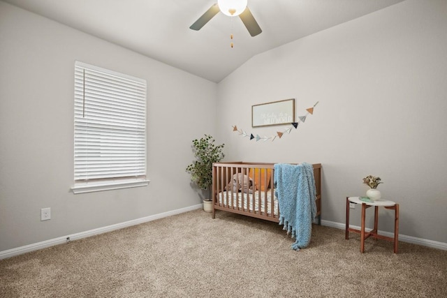 carpeted bedroom with a nursery area, ceiling fan, and lofted ceiling