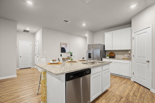 kitchen with a kitchen island with sink, white cabinetry, and appliances with stainless steel finishes