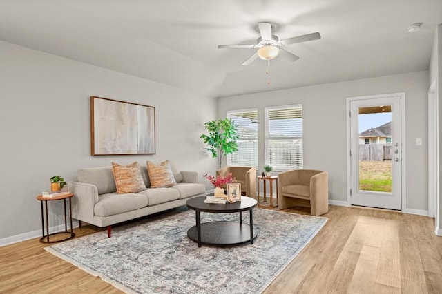 living room with lofted ceiling, light hardwood / wood-style flooring, and ceiling fan