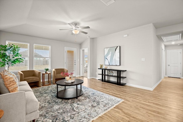 living room with vaulted ceiling, ceiling fan, and light wood-type flooring