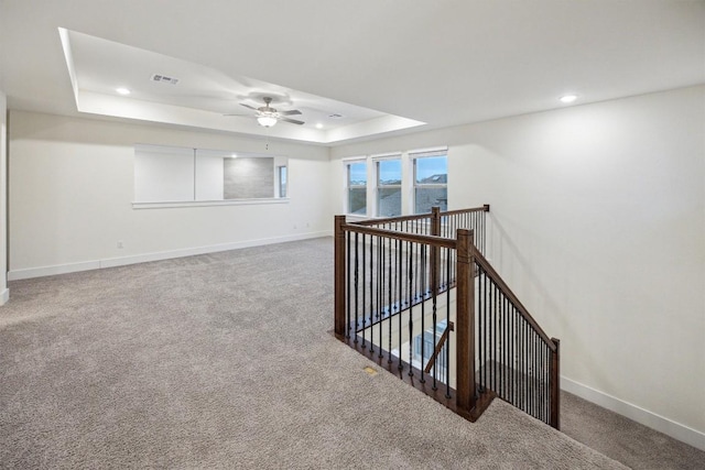 interior space with ceiling fan and a tray ceiling