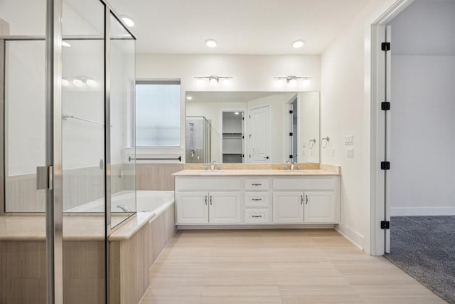 bathroom with vanity and shower with separate bathtub