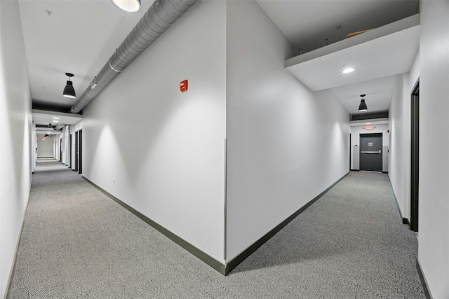 hall featuring carpet and baseboards