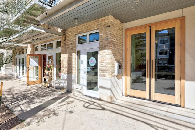 property entrance featuring french doors and brick siding