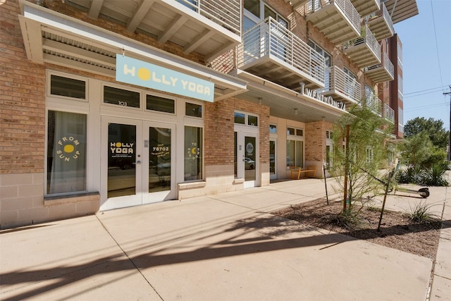 doorway to property featuring french doors and brick siding