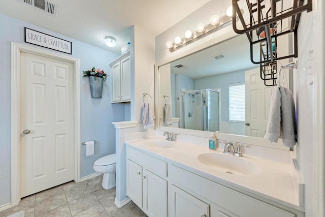 bathroom with a shower with door, vanity, tile patterned flooring, and toilet