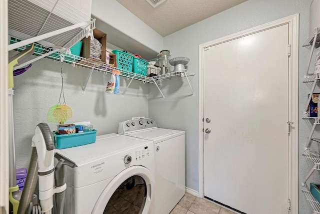 laundry area featuring light tile patterned floors and washer and clothes dryer