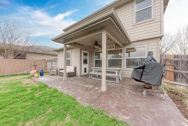 rear view of house with ceiling fan, a patio area, and a lawn