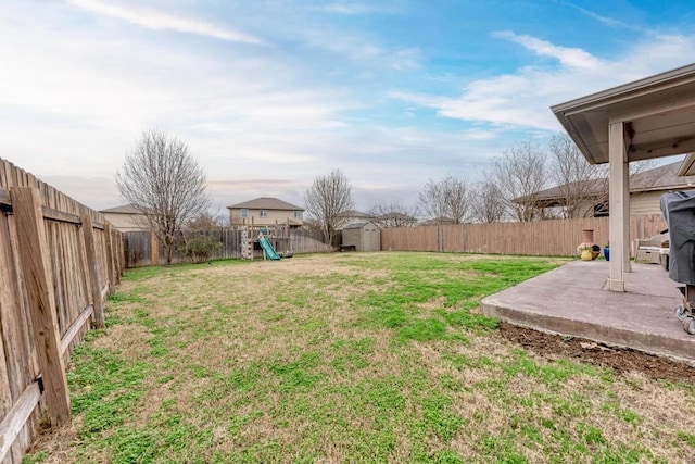 view of yard with a storage shed, a playground, and a patio