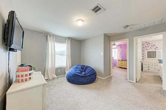 interior space with connected bathroom, light carpet, and a textured ceiling