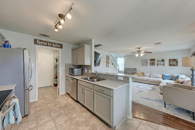 kitchen with sink, gray cabinetry, ceiling fan, kitchen peninsula, and stainless steel appliances