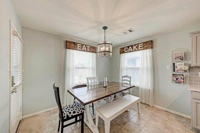 dining area with a notable chandelier and a textured ceiling