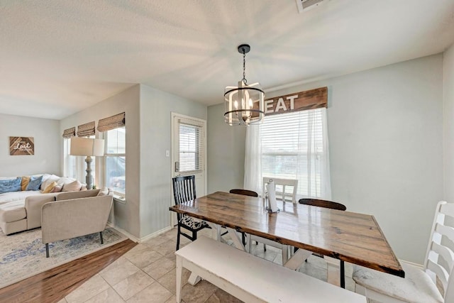 dining space with a chandelier and light tile patterned flooring