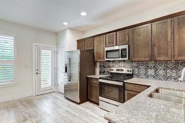 1801 Roseburg Dr Unit 29, Austin, TX 78754 - kitchen featuring tasteful backsplash, sink, dark brown cabinetry, stainless steel appliances, and light wood-type flooring