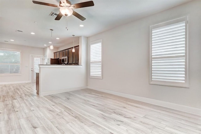 1801 Roseburg Dr Unit 29, Austin, TX 78754 - interior space with ceiling fan, refrigerator, light wood-type flooring, and decorative light fixtures