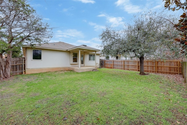 rear view of house with a patio and a yard