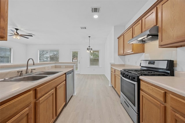 kitchen with decorative light fixtures, sink, ceiling fan, stainless steel appliances, and light hardwood / wood-style flooring