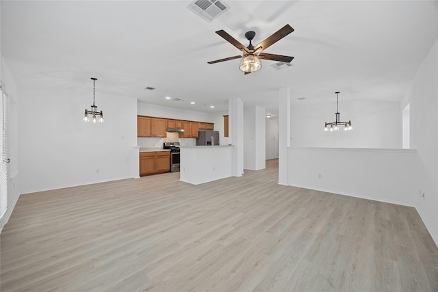 unfurnished living room with ceiling fan with notable chandelier and light wood-type flooring