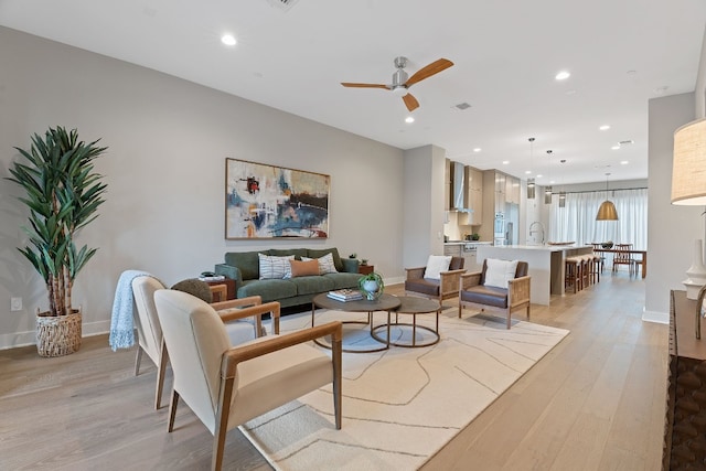 living room featuring ceiling fan and light wood-type flooring