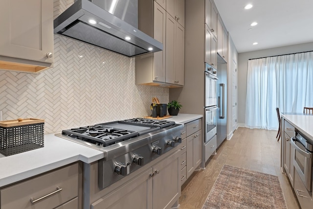 4510 Unity Cir Unit 258, Austin, TX 78731 - kitchen with wall chimney range hood, gray cabinetry, appliances with stainless steel finishes, recessed lighting, and decorative backsplash