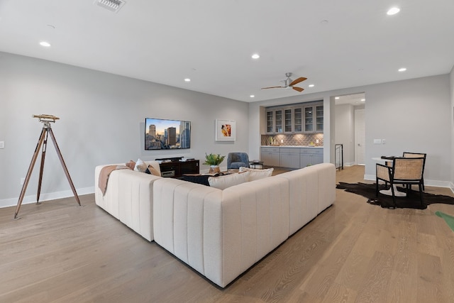 living room featuring light hardwood / wood-style floors and ceiling fan