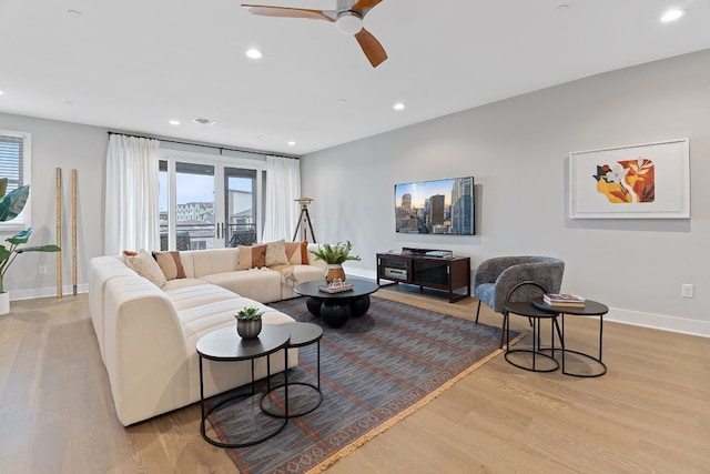 living room featuring ceiling fan and light hardwood / wood-style floors