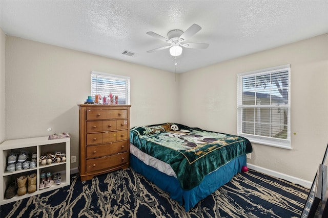 bedroom featuring ceiling fan and a textured ceiling