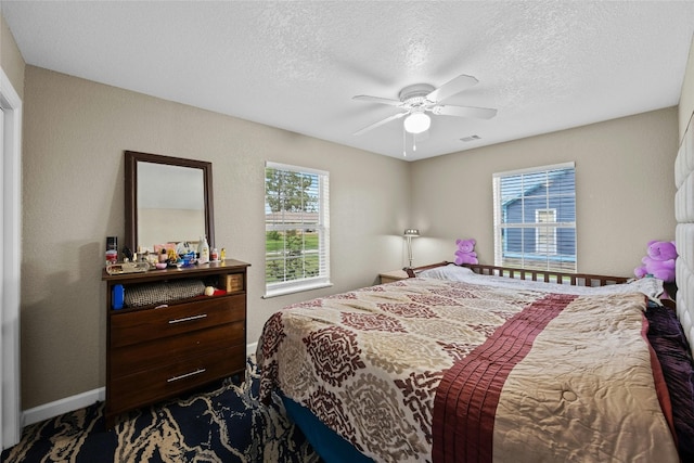 carpeted bedroom with ceiling fan and a textured ceiling