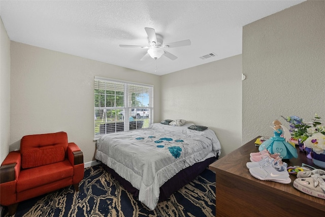 bedroom with ceiling fan and a textured ceiling