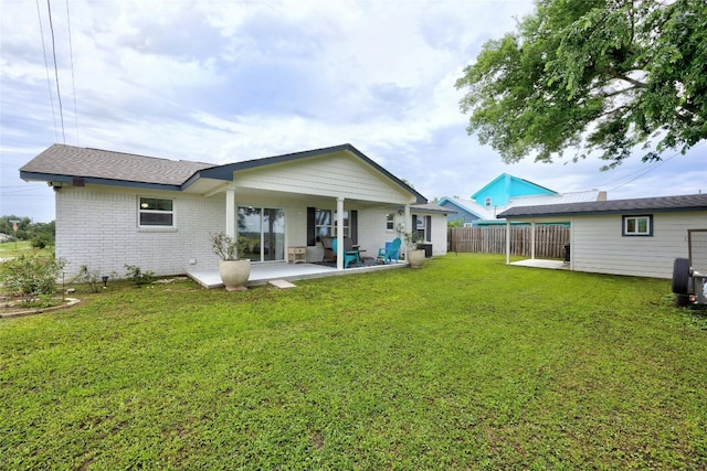 back of property with a yard and a patio