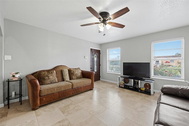 living room with ceiling fan and a textured ceiling